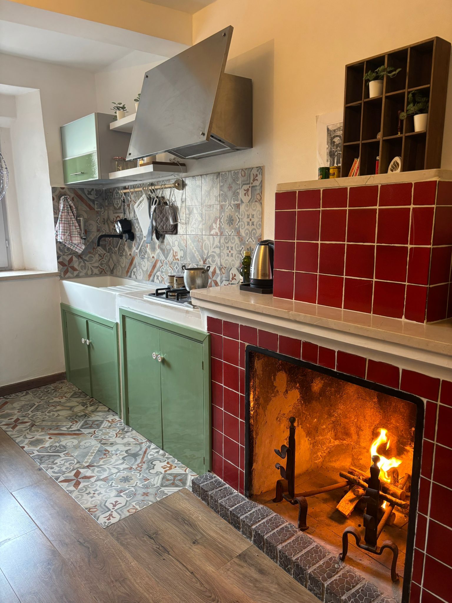 Cucina rustica con camino acceso e piastrelle artistiche